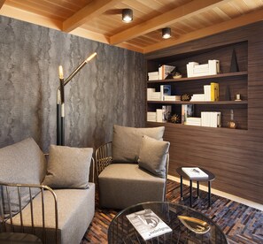 A modern living room with a sofa, armchairs, a coffee table, and a bookshelf.
