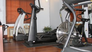 A gym with stationary bikes, treadmills, and a fan. - Gladstone Inn & Suites (Jamestown)