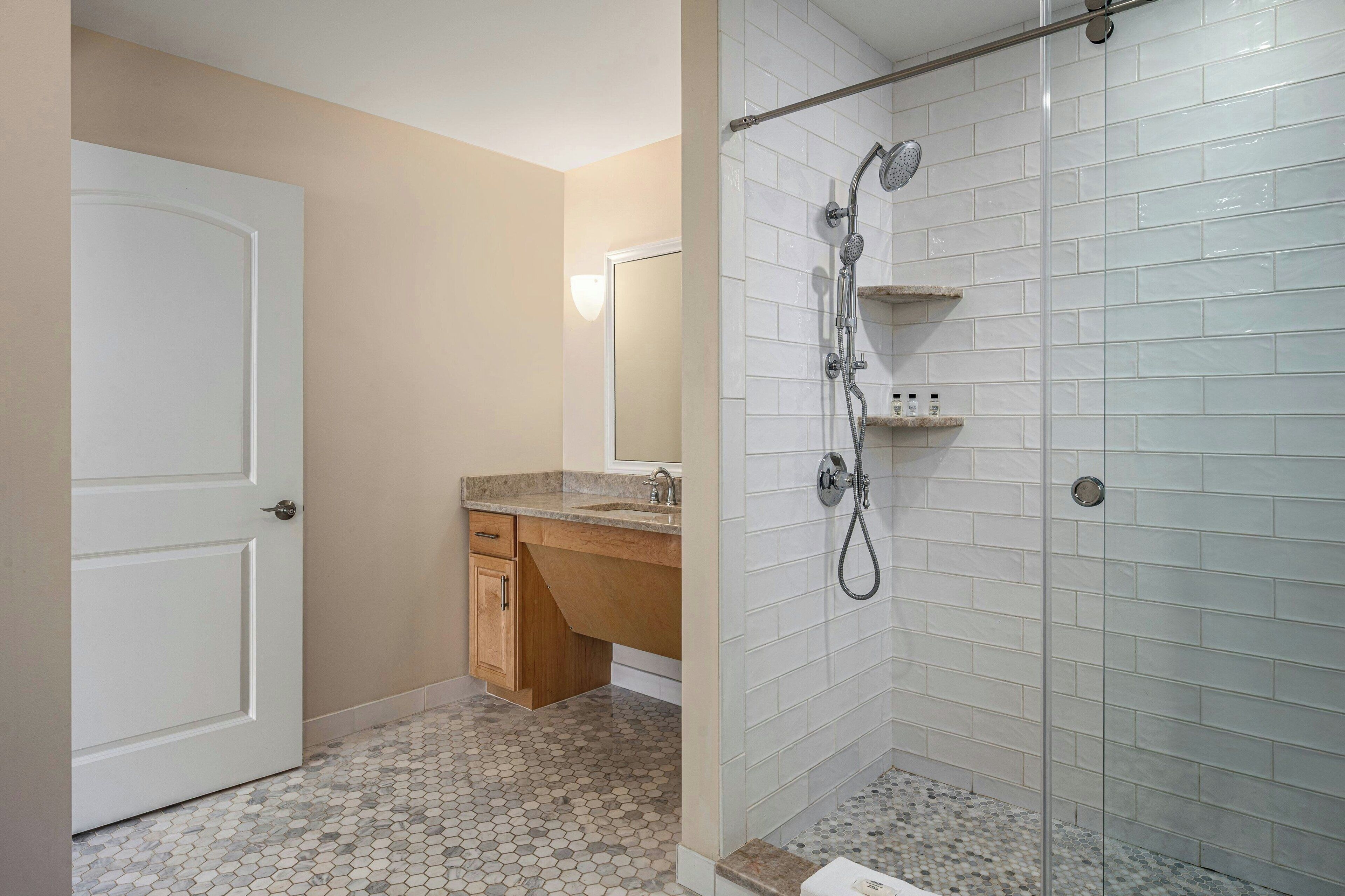 A bathroom with a shower, a sink, and a toilet.