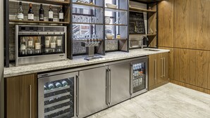 A modern kitchen with stainless steel appliances, wooden cabinets, and a wine display. - New Haven Hotel (New Haven)