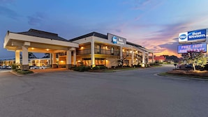 A Best Western hotel with a Colonial Inn sign, a gas station, and a 'FREE HOT BREAKFAST' sign.
