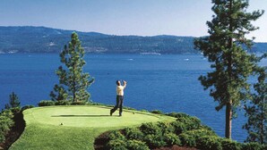 A golf course with a view of a large body of water and hills in the background. - The Coeur D'alene Golf and Spa Resort (Coeur d'Alene)