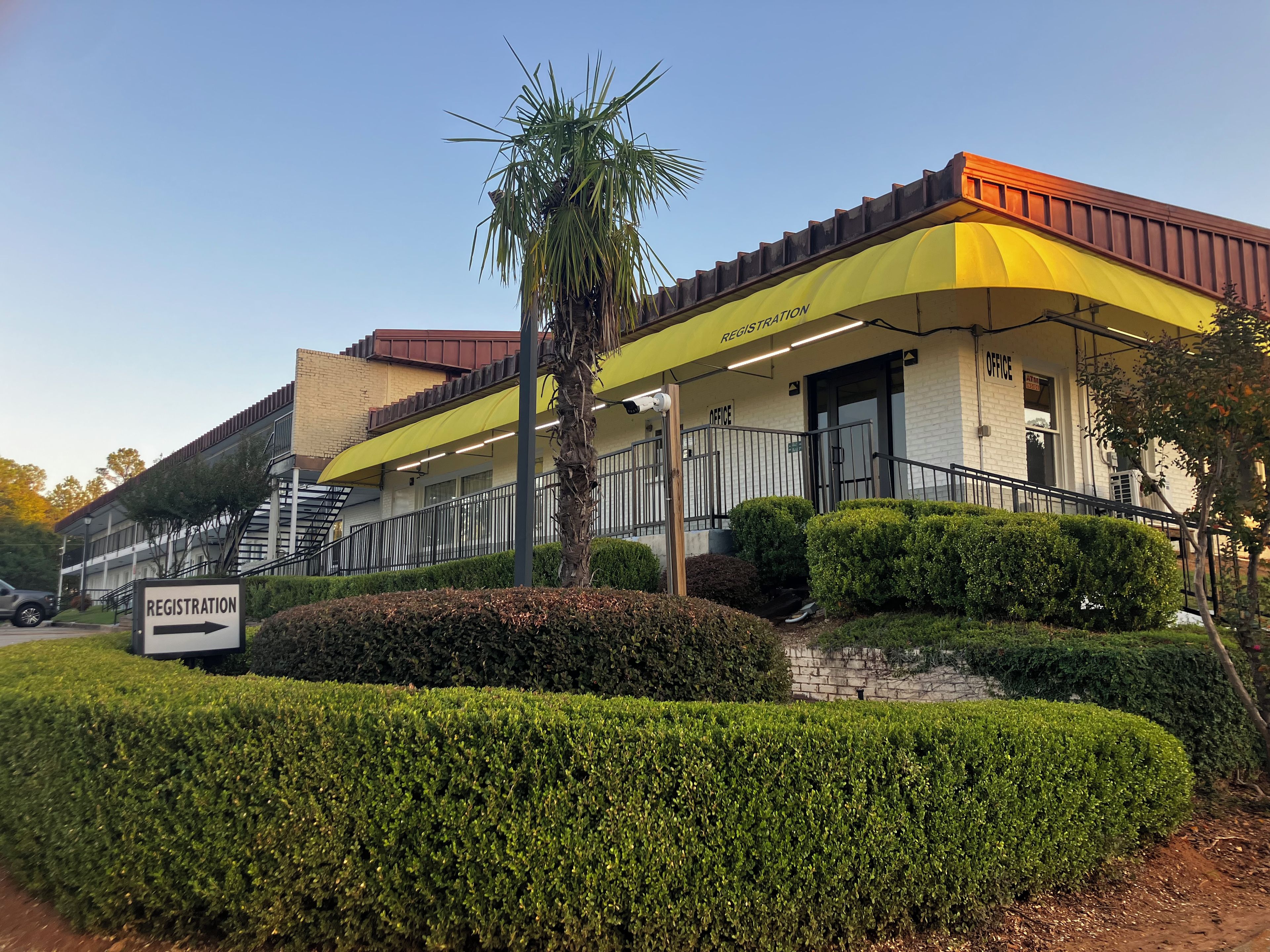A building with a registration sign, an office, and a staircase leading to an upper level.