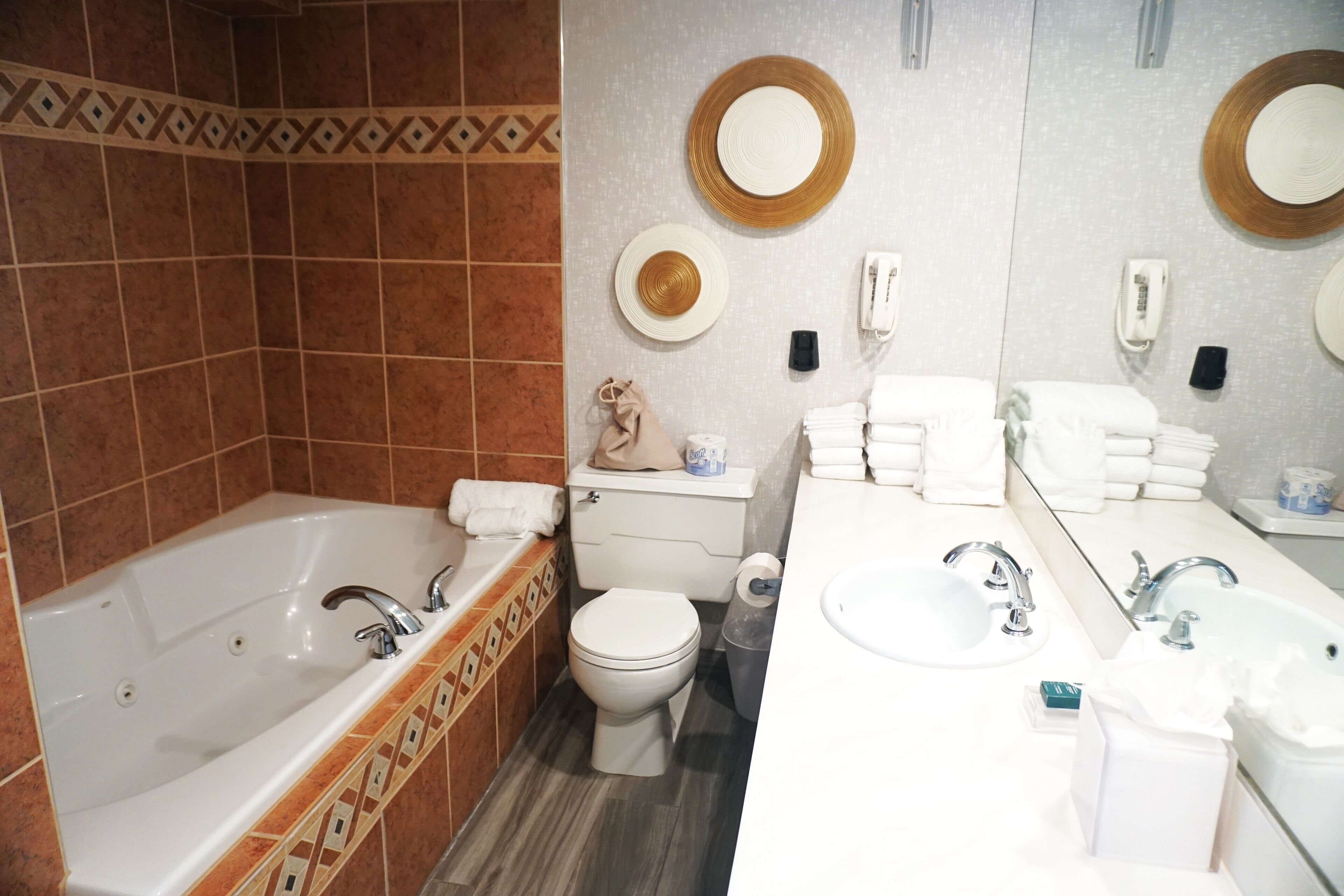 A bathroom with a bathtub, toilet, and two sinks.