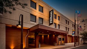 A hotel with a prominent "Hilton" sign, a covered entrance, and an American flag. - Hilton Appleton Paper Valley (Appleton)