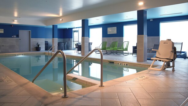 A swimming pool with a metal ladder, lounge chairs, and a chair lift. - Hampton Inn Glendale Milwaukee, WI (Milwaukee)