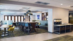 A modern hotel lobby with seating areas, a coffee station, and a reception desk. - Hampton Inn Glendale Milwaukee, WI (Milwaukee)
