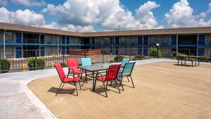 Un motel con patio y mobiliario para exteriores.