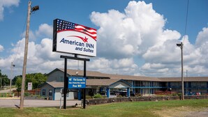 Un American Inn and Suites con un cartel, un televisor de pantalla plana y una mención de WiFi gratuito.