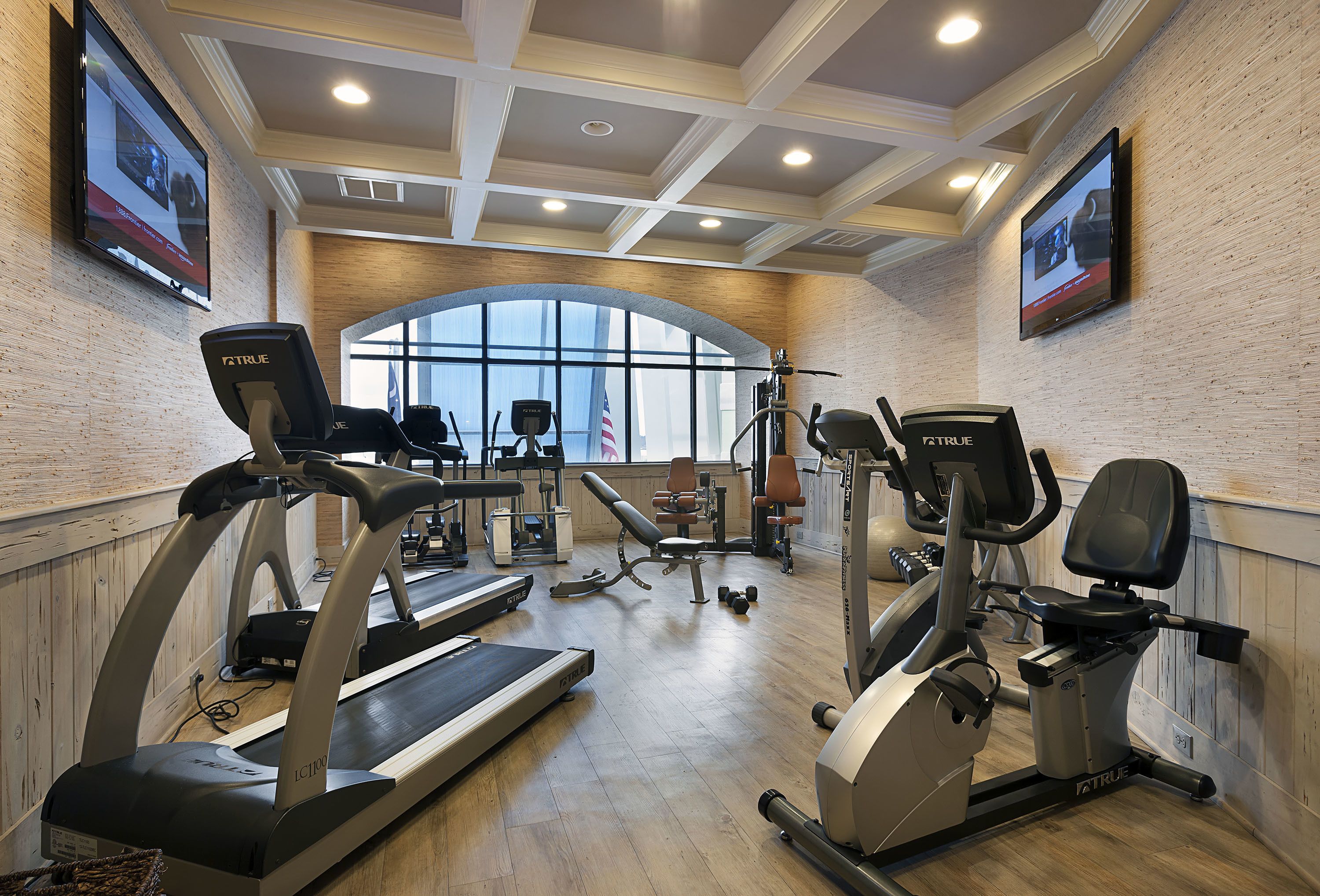 A gym with treadmills, elliptical machines, and weight equipment.
