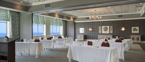 A conference room with multiple tables, chairs, and a podium.