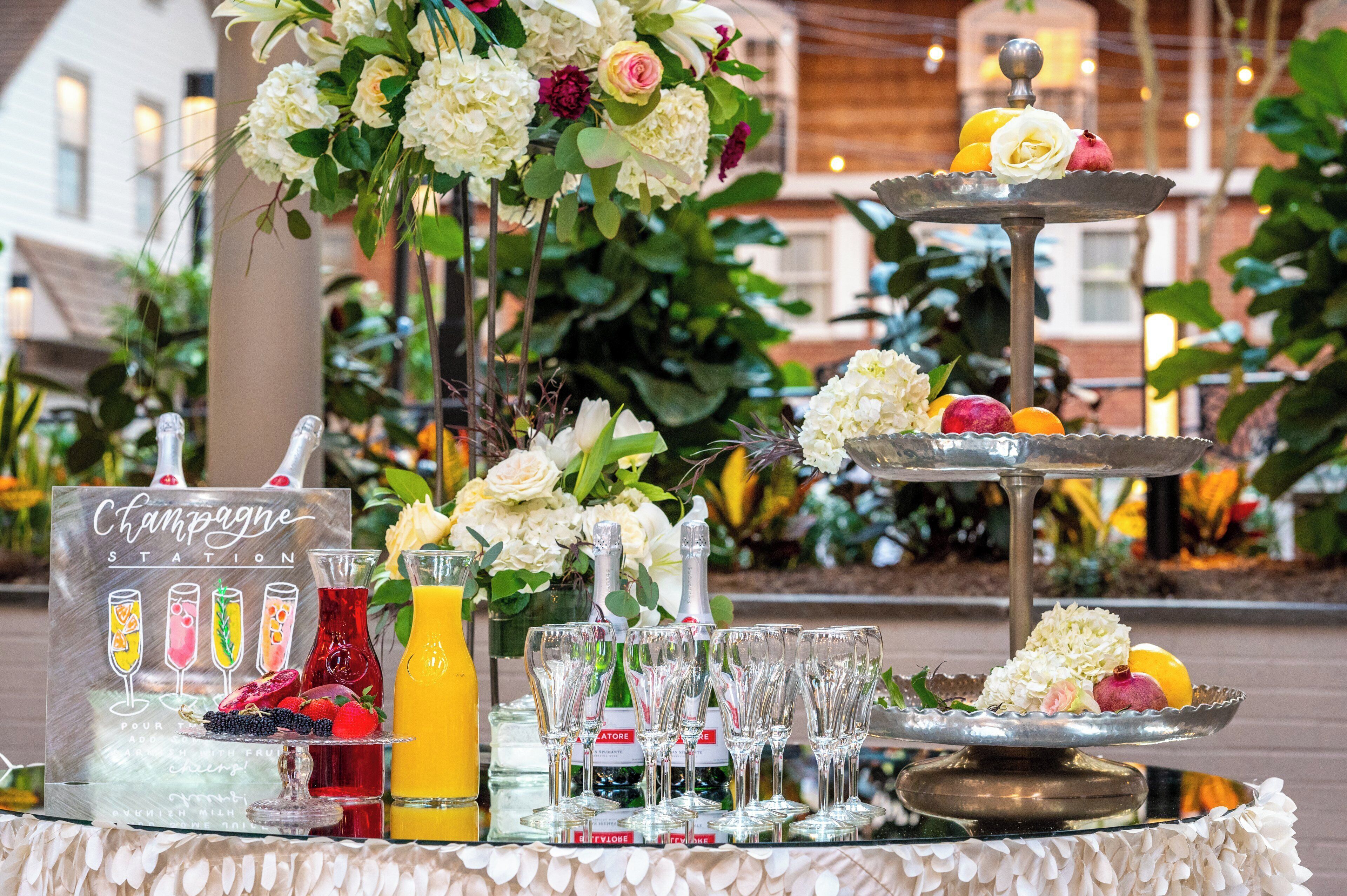 A table set with champagne glasses, a bottle of champagne, and a sign indicating a champagne station.