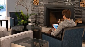 A modern living room with a fireplace, a glass coffee table, and a comfortable seating area.