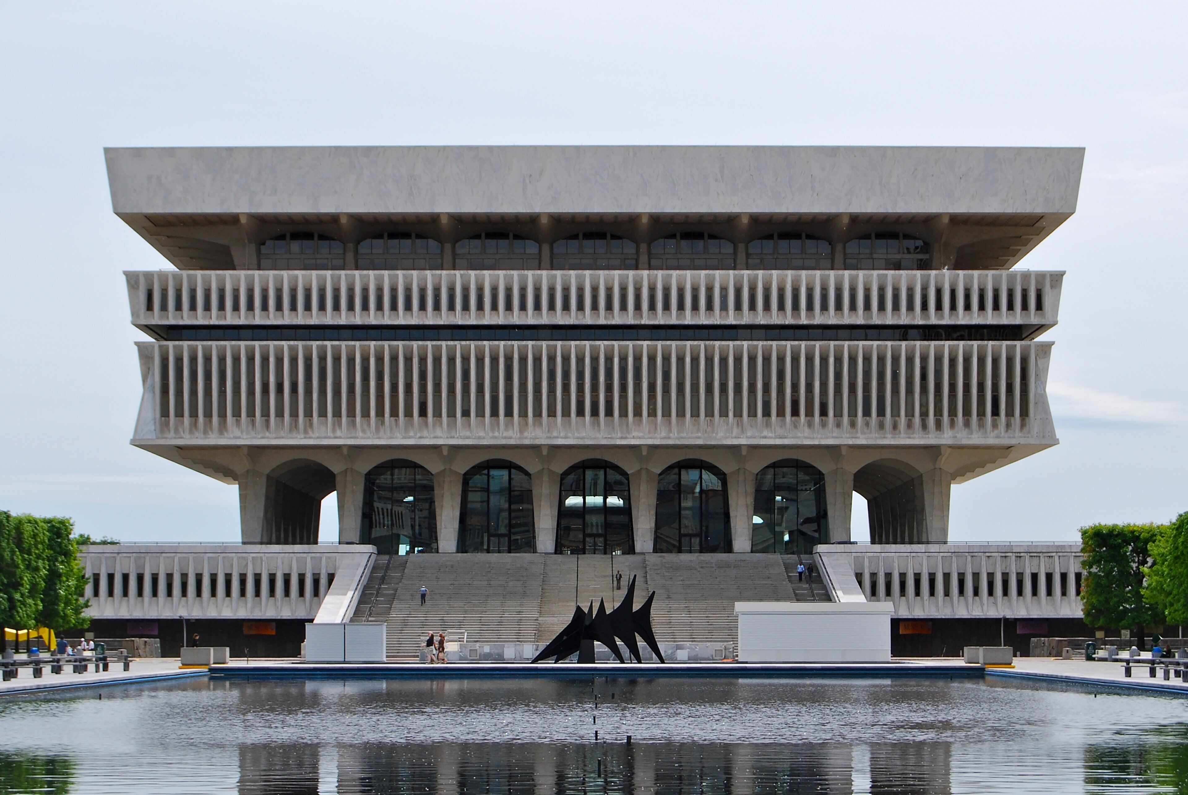A modern building with a unique architectural design, featuring multiple levels and a central courtyard with a reflective water feature.