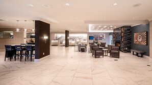 A spacious lobby with a seating area, a reception desk, and a modern fireplace.