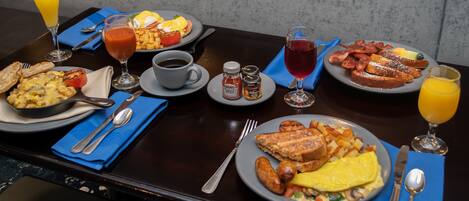 A breakfast buffet with various dishes, drinks, and condiments.