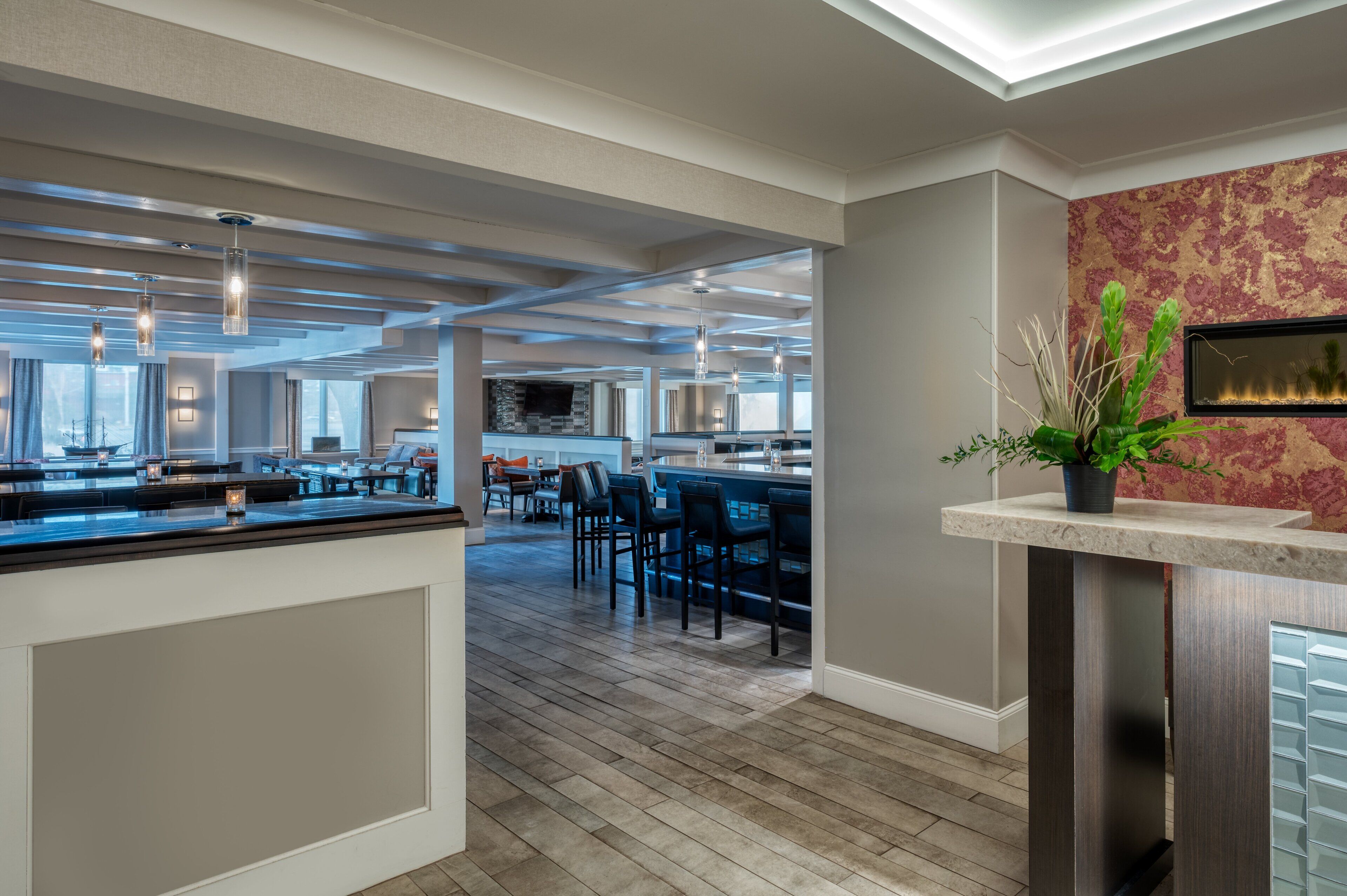 A spacious kitchen with modern appliances, a dining area with chairs, and a bar area with a countertop and pendant lights.