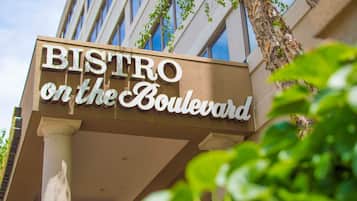 A sign for 'BISTRO on the Boulevard' with a clear view of the building's facade and columns.