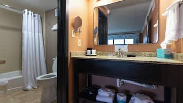 A bathroom with a toilet, shower, and sink.