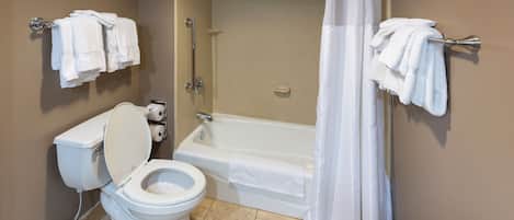 Een badkamer met toilet, bad en douchegordijn.