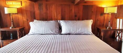 A room with a bed, two nightstands, and a sign that reads "LOW BEAM".