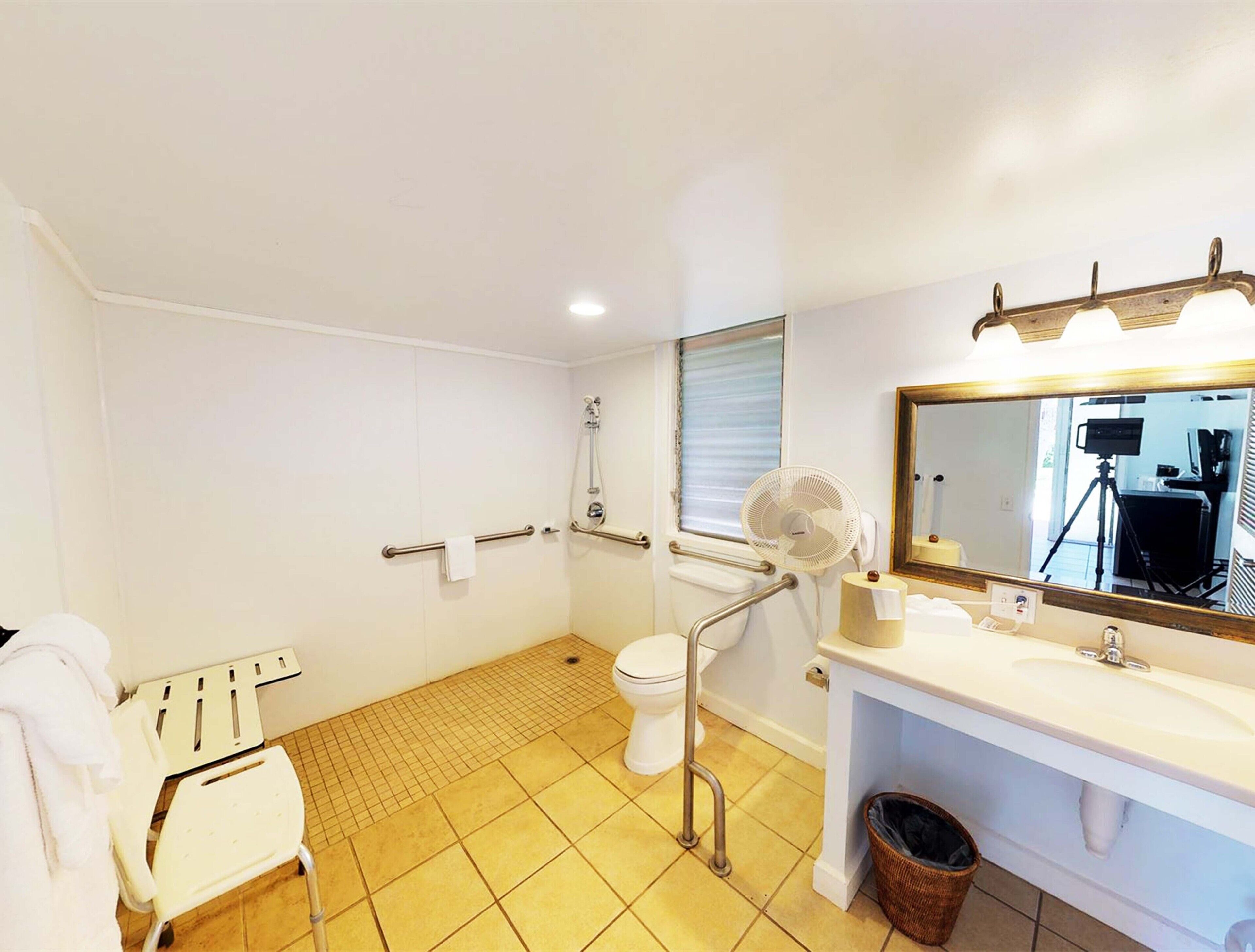 Un bagno con WC, bidet, doccia e lavandino con specchio.