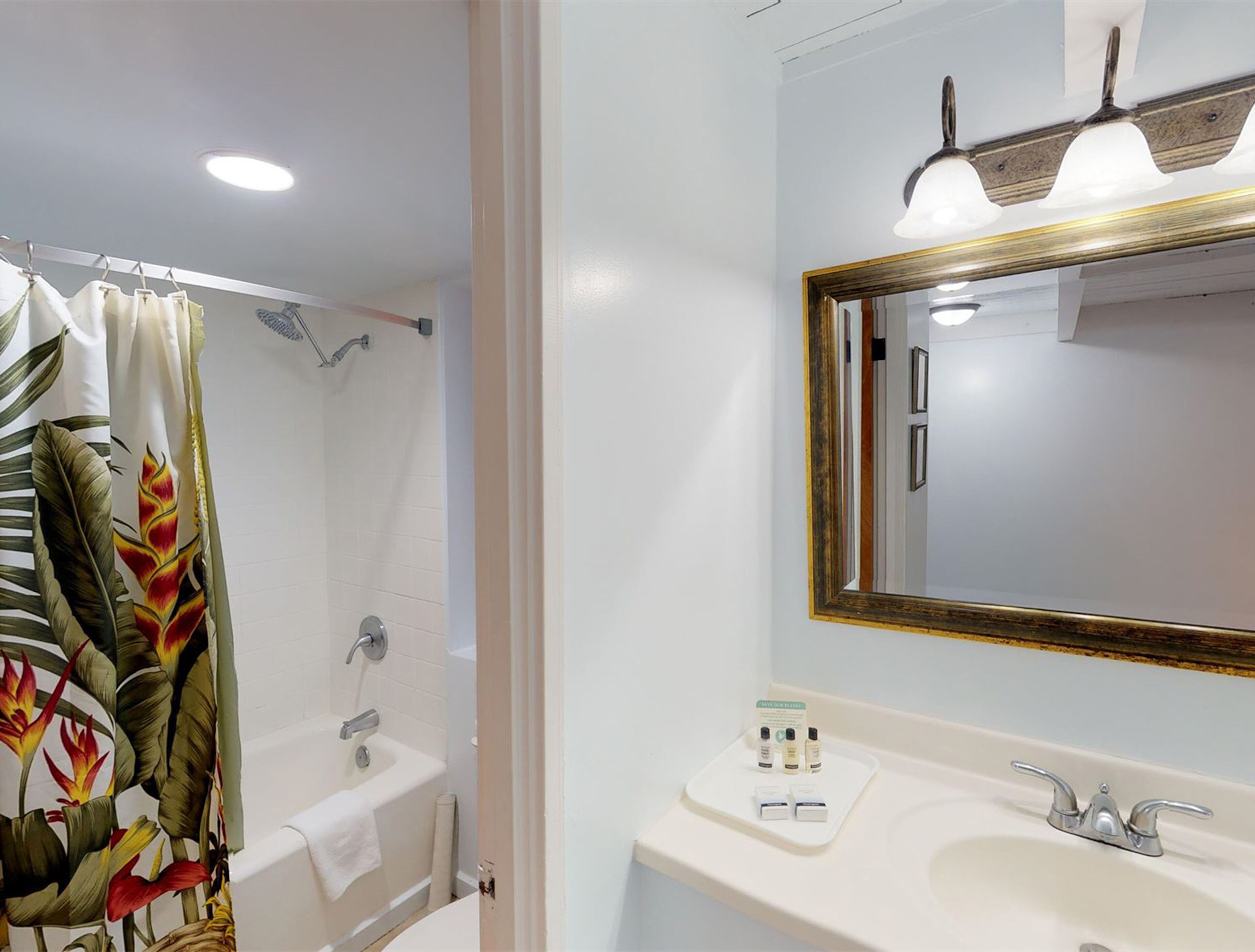 A bathroom with a shower, a sink, and a mirror.