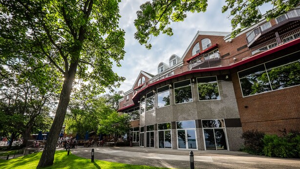 A multi-story building with a brick facade, large windows, and a red awning. - Heidel House Resort & Spa (Green Lake)