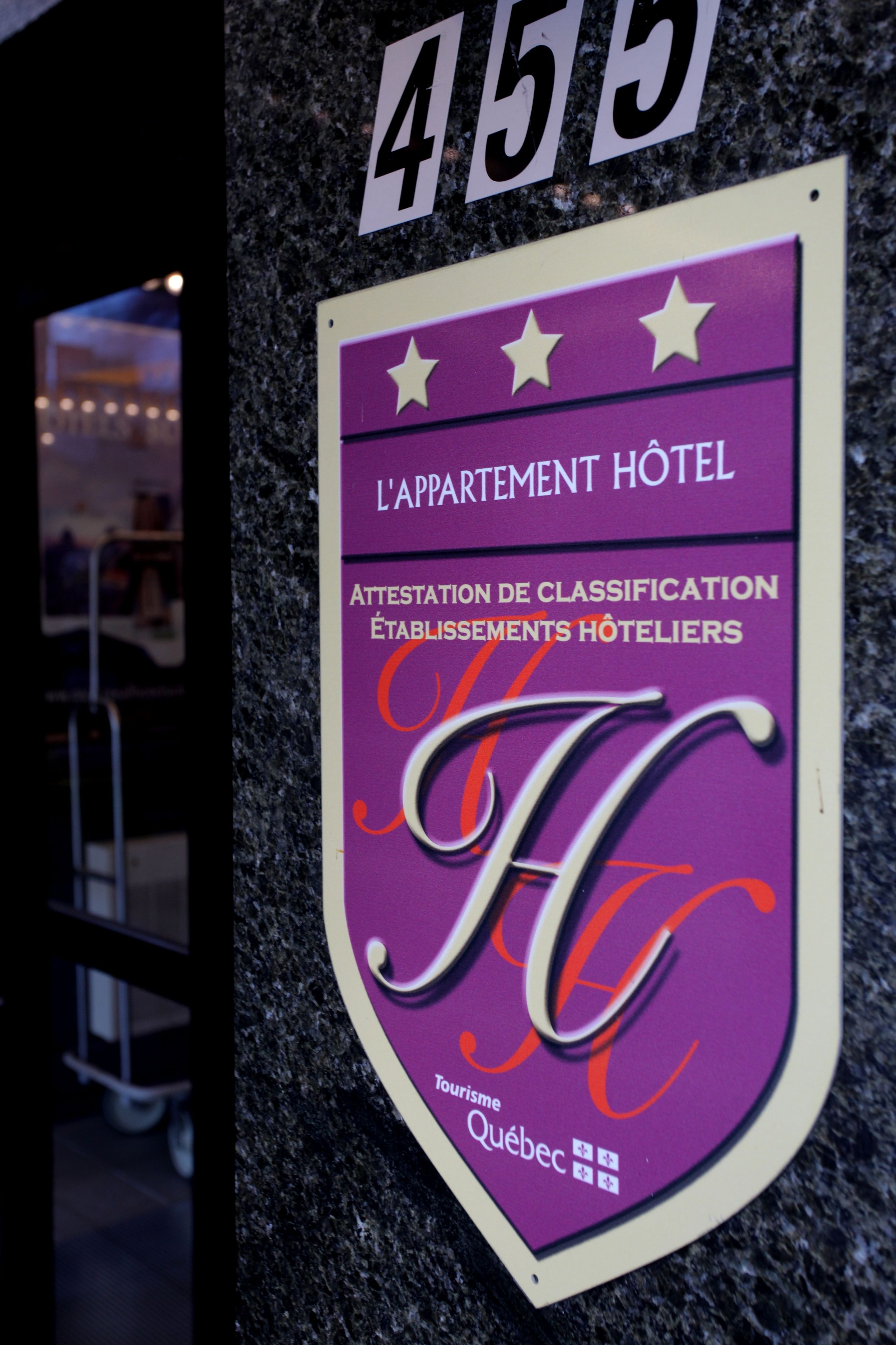 Et hotelskilt med nummer 455 og et logo, der angiver, at det er et 4-stjernet hotel i Quebec.