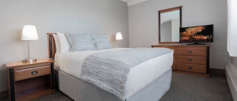 A hotel room with a bed, nightstands, a dresser, a TV, and a mirror.