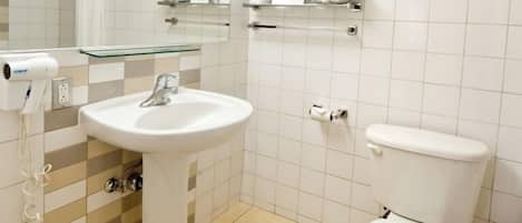 A bathroom with a sink, toilet, and towel racks.