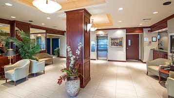 A spacious lobby with a reception desk, seating area, and a large decorative column.