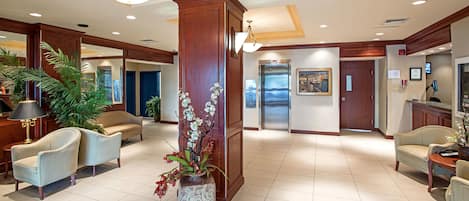 A spacious lobby with a reception desk, seating area, and a large decorative column.