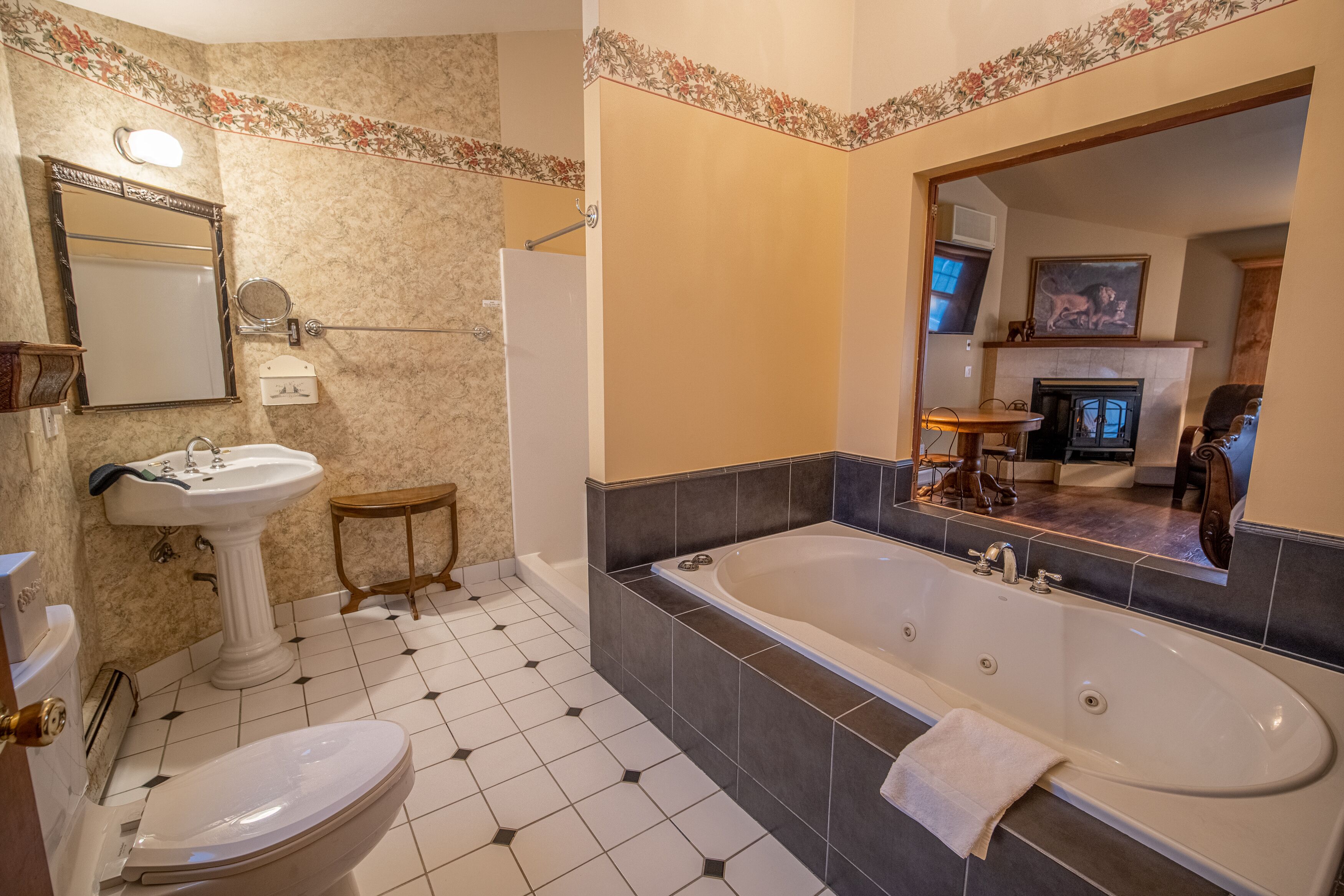 A bathroom with a toilet, sink, bathtub, and a mirror.