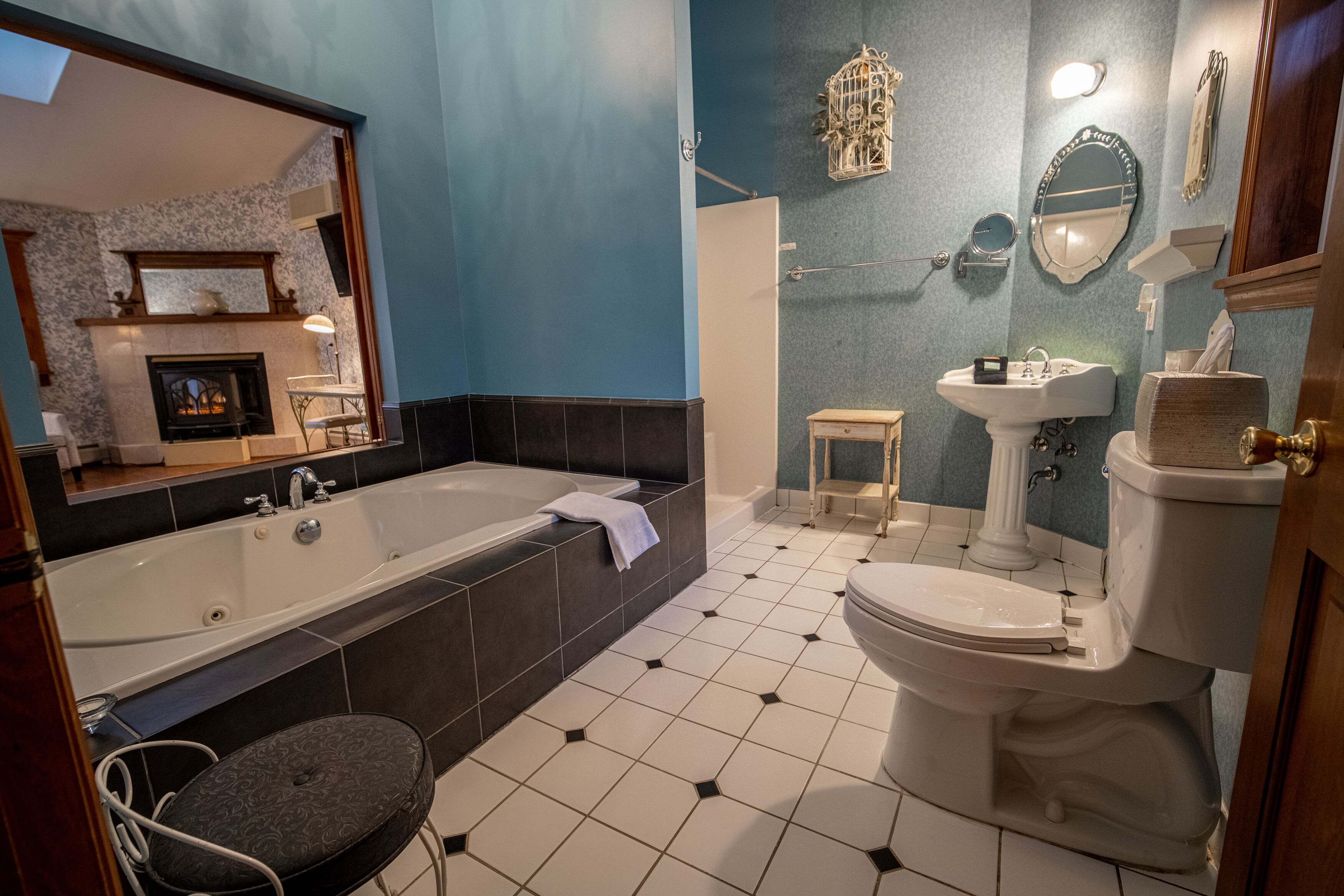 A bathroom with a large bathtub, a toilet, a sink, and a mirror.