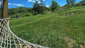 A grassy field with a wooden structure overhead, possibly a gazebo or pavilion. - Albergo Allegria Hotel (Windham)