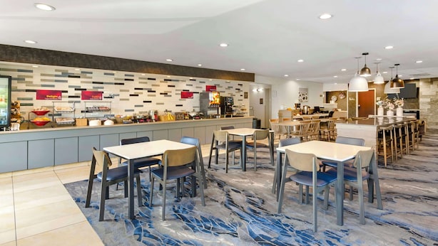 Un restaurante moderno con mostrador, varias mesas y sillas.