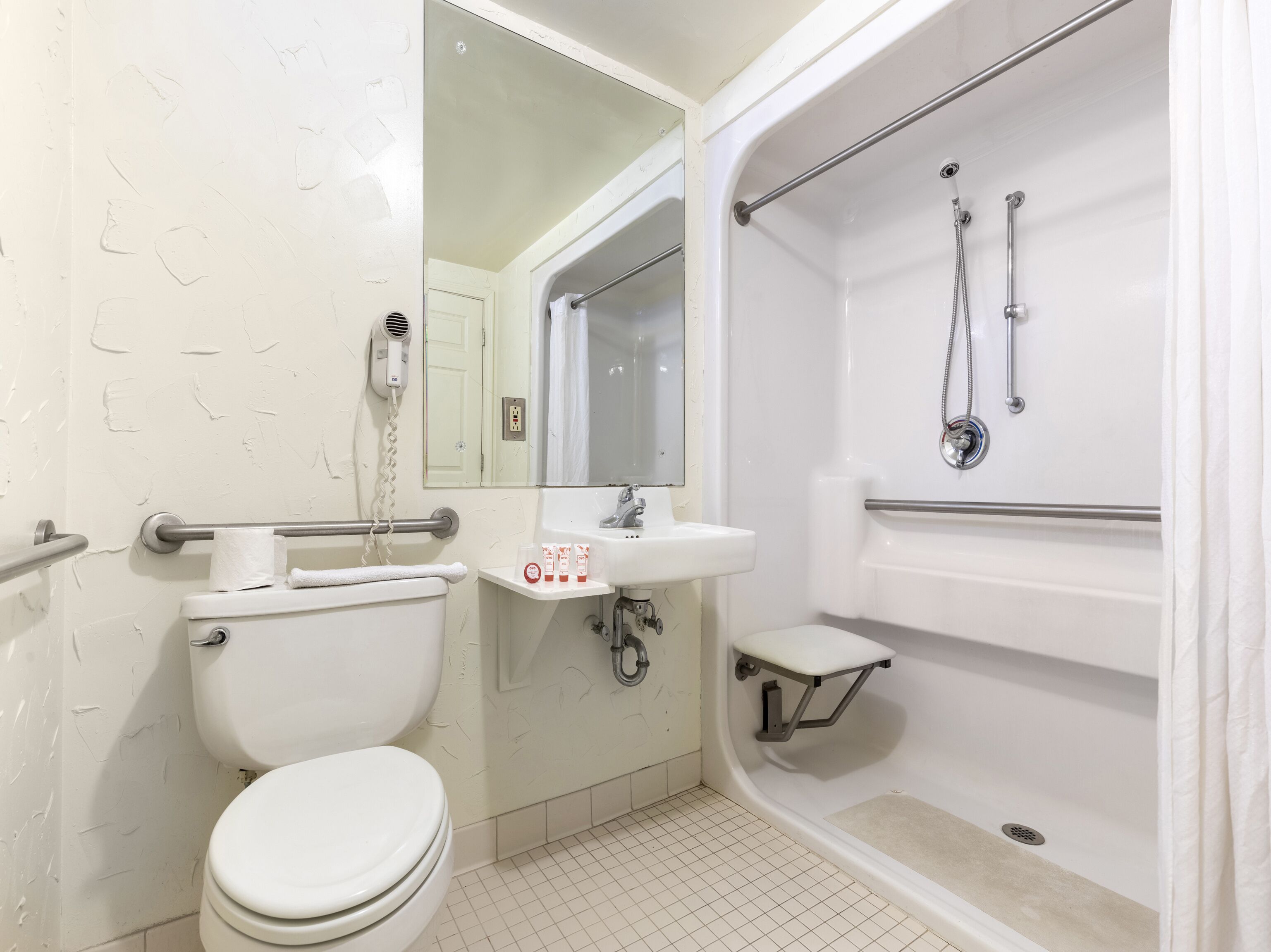 A bathroom with a toilet, sink, and shower.