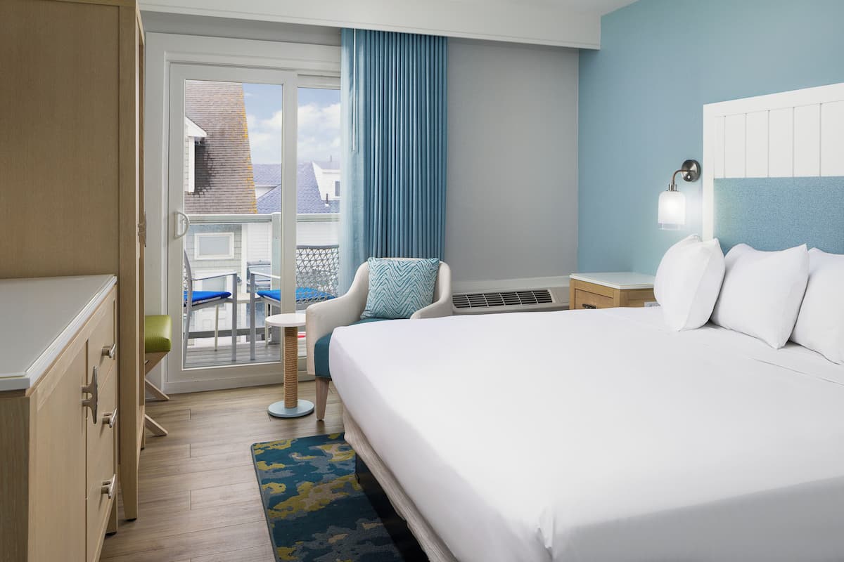 Ein Hotelzimmer mit Bett, Sessel, Schreibtisch und Blick nach draußen.