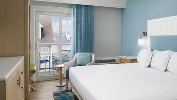 Habitación de hotel con cama, una silla, un escritorio y vistas al exterior.