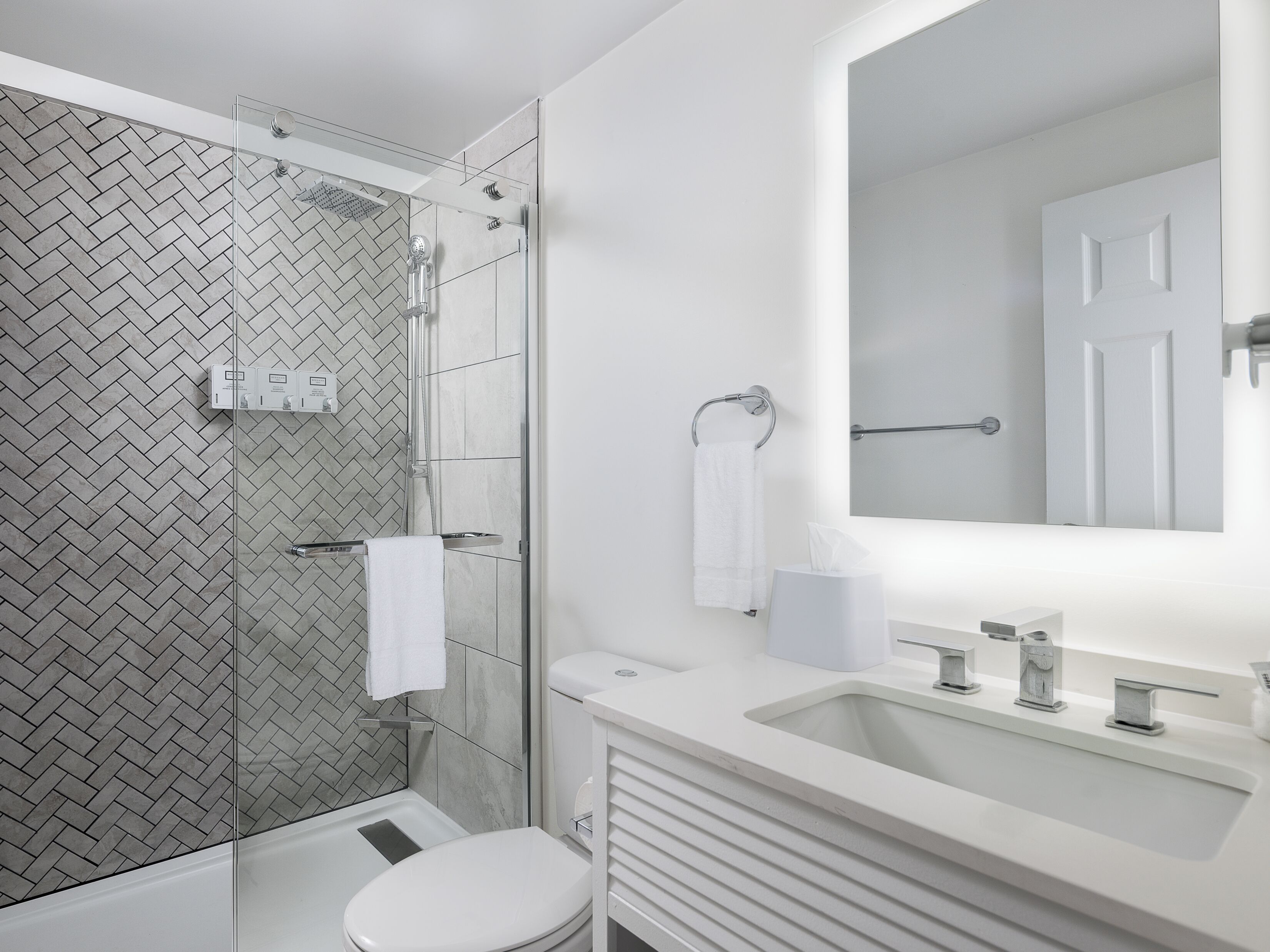 A modern bathroom with a shower, toilet, and sink.