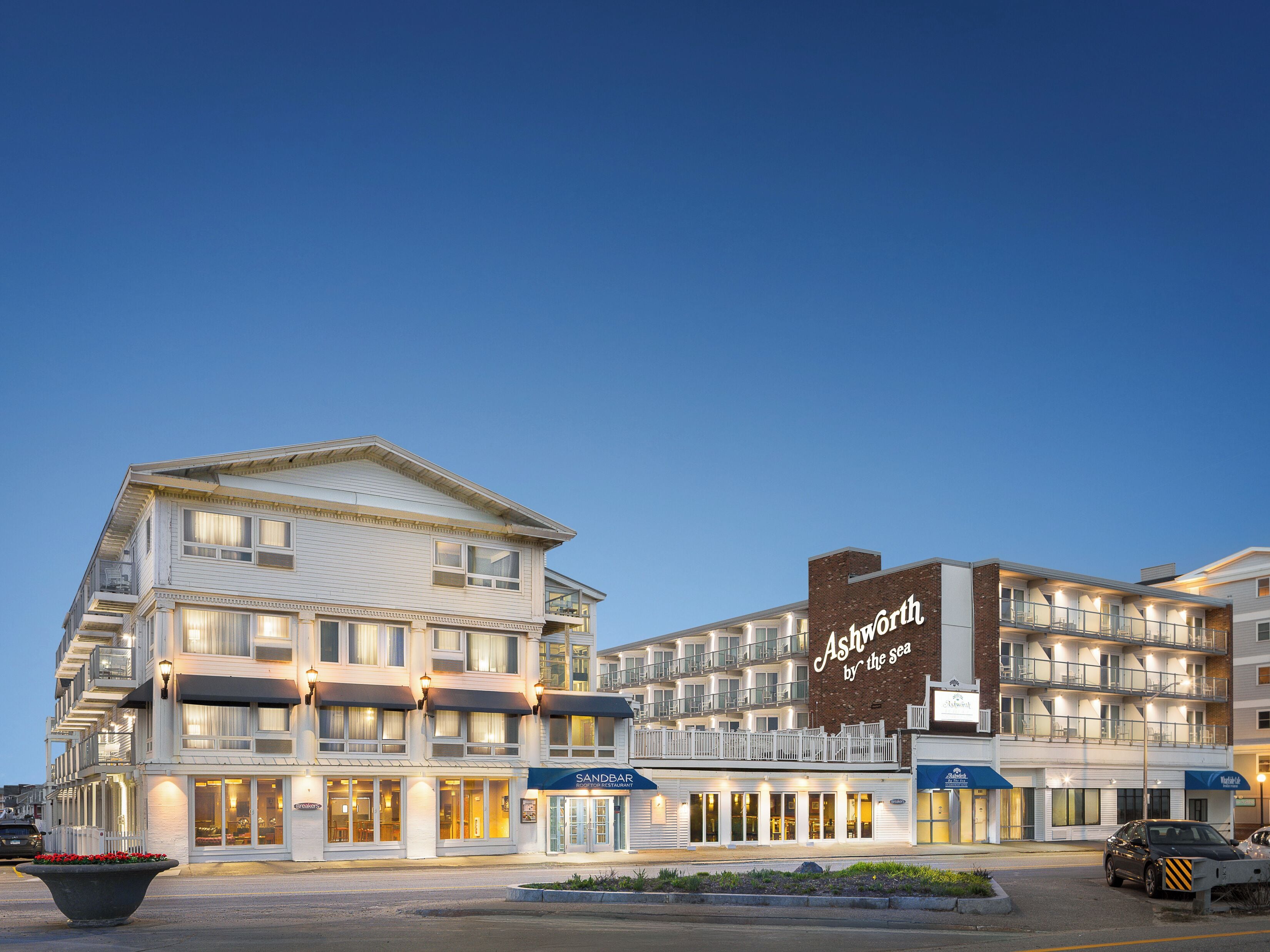A multi-story hotel with a prominent sign reading 'Asworth by the sea,' featuring a beachside location.