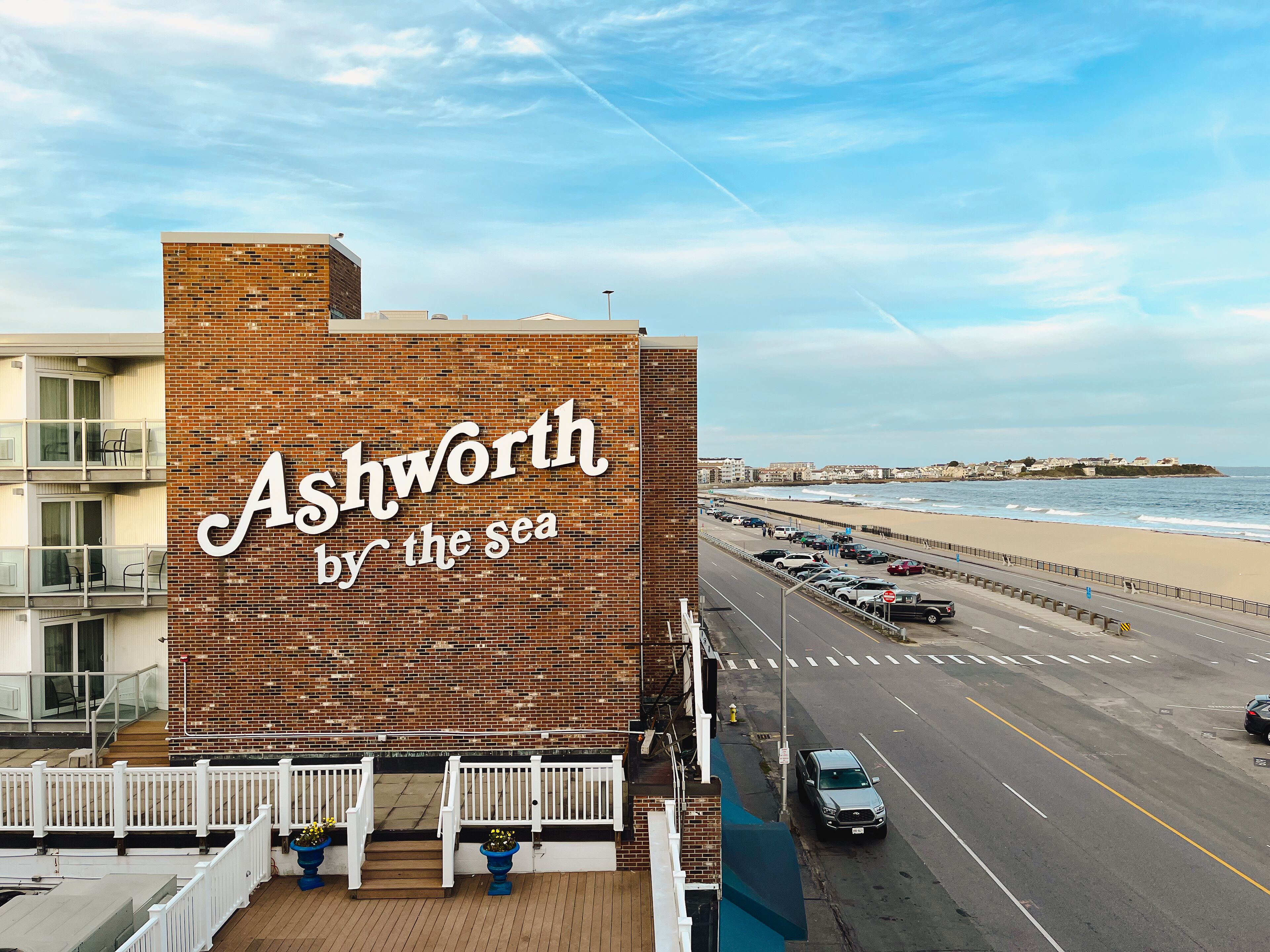 A building with a sign reading "Ashworth by the sea" and a view of the beach and ocean.