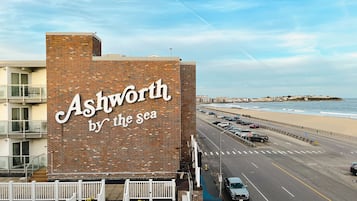 A building with a sign reading "Ashworth by the sea" and a view of the beach and ocean.