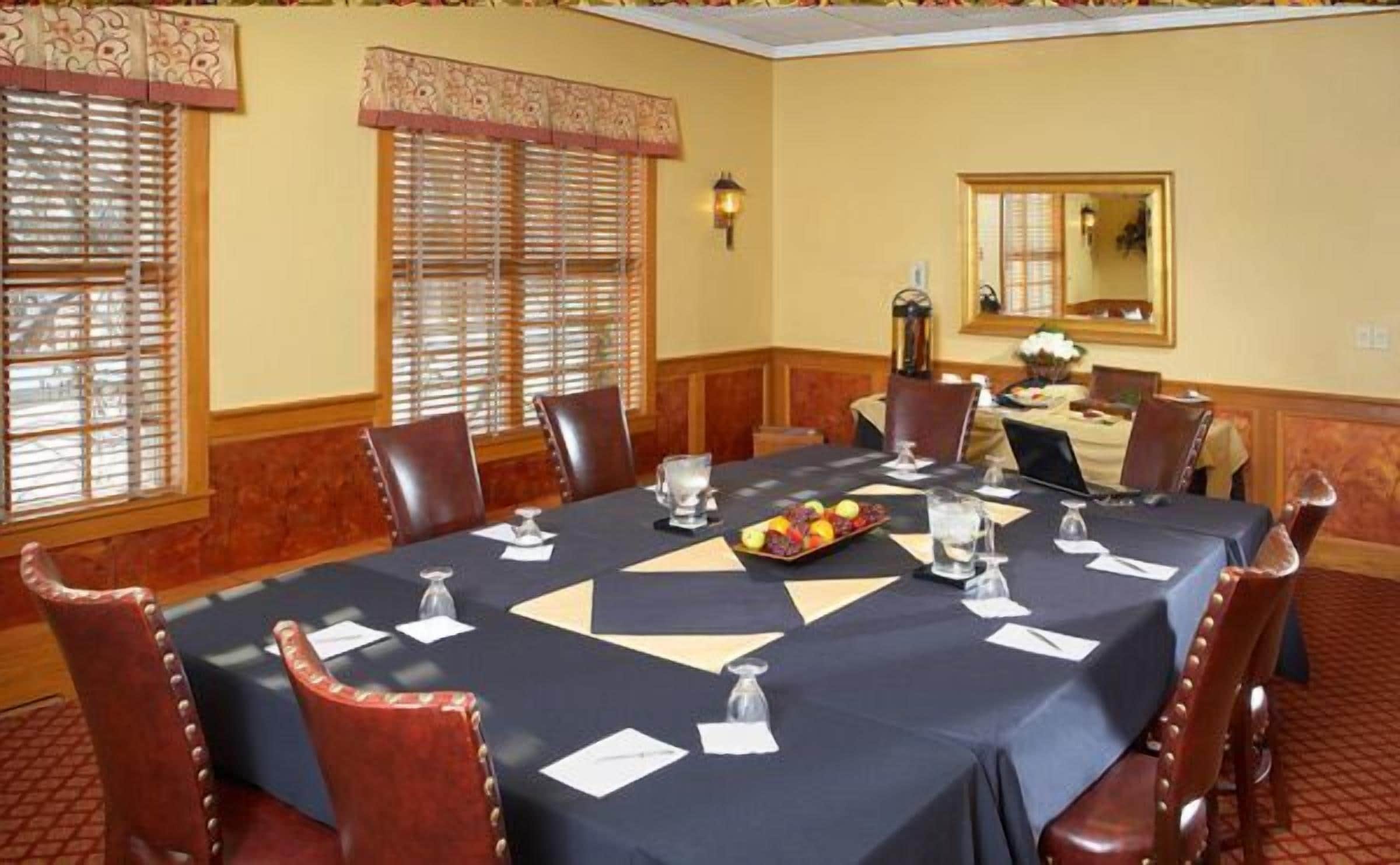 A conference room with a large table, chairs, and a fruit tray.