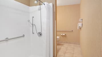 A modern bathroom with a shower, toilet, and towel rack.