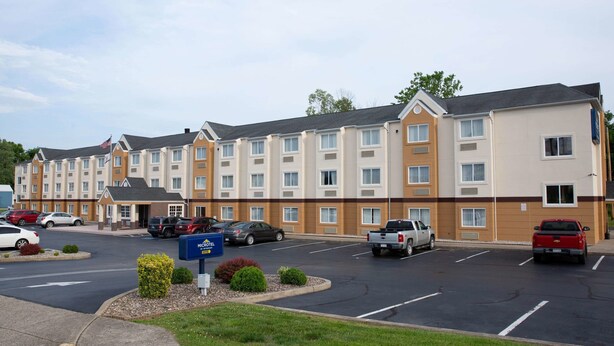 Un hôtel à plusieurs étages doté d’un parking, de plusieurs véhicules et d’une enseigne indiquant qu’il s’agit d’un hôtel Marriott.