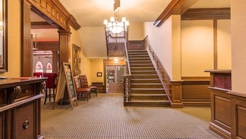 A grand staircase with wooden railings and a patterned carpet.