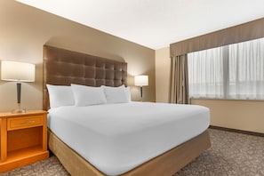 A hotel room with a large bed, two bedside tables, a headboard, and a window with curtains. - Drury Plaza Hotel St. Louis Union Station (St. Louis)