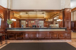 A reception desk with a marble top, wooden paneling, and a sign indicating it's the Drury Inn. - Drury Plaza Hotel St. Louis Union Station (St. Louis)